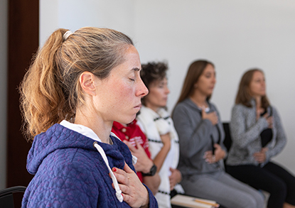 Person deep breathing with their hand on their chest