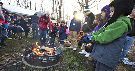 Roasting s'mores outdoors by the bon fire at Plymouth's Old Fashioned Christmas event