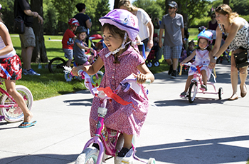 Child riding a decorated bike during the Happy Birthday America Parade